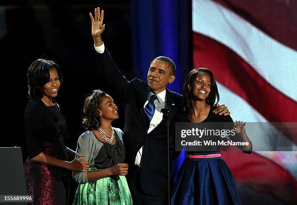 President Barack Obama walks on stage with first lady Michelle Obama and daughters Sasha and Malia to deliver his victory speech on election night at...