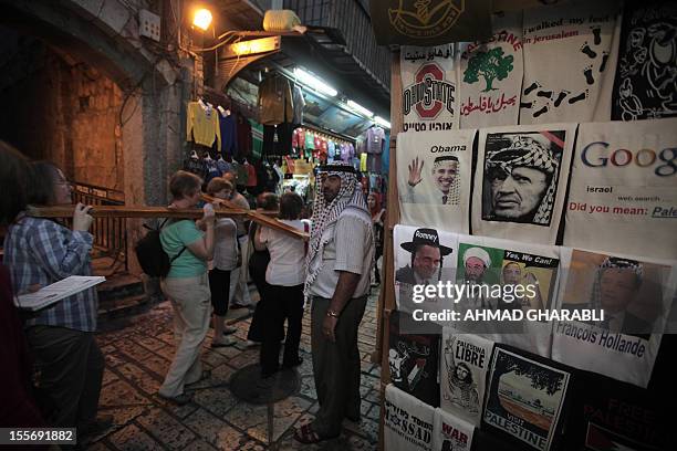 Christian tourists carry a cross past a souvenir shop in Jerusalem's old city displaying t-shirts for sale among them one of US Republican...