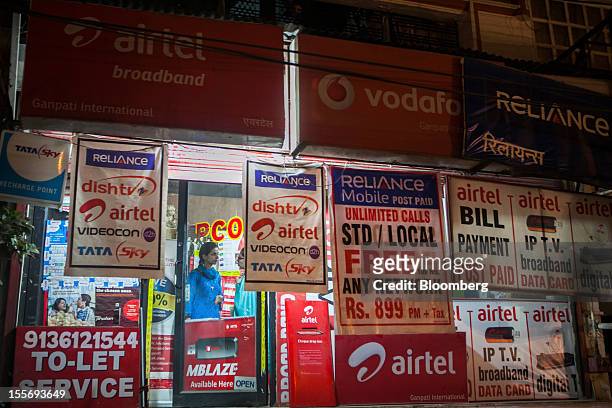 Advertisements for mobile and internet services are displayed outside a store in New Delhi, India, on Tuesday, Nov. 6, 2012. Bharti Airtel Ltd.,...