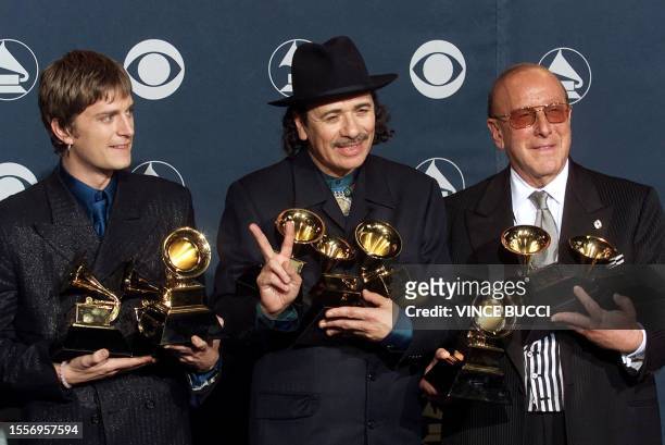 Musician Carlos Santana singer Rob Thomas and Arista Records President Clive Davis hold nine Grammy awards including ones for Song of the Year for...
