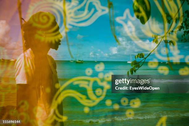 Local people selling knitted bikinis and scarfs along the beach with local sailing and fishing boats near pigeon point on October 21, 2012 in...