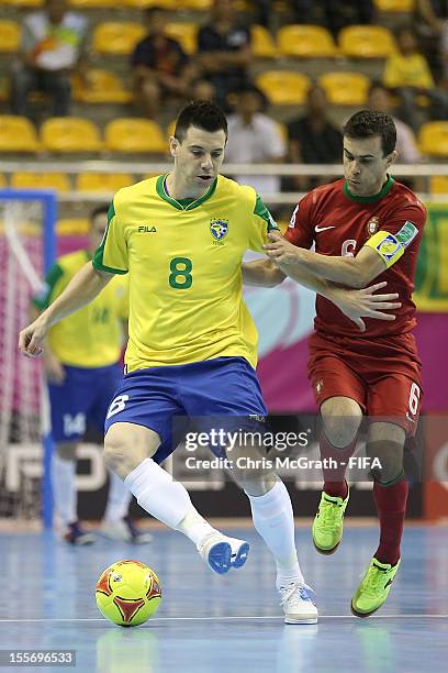 Simi of Brazil contests the ball with Arnaldo of Portugal during the FIFA Futsal World Cup, Group C match between Portugal and Brazil at Korat...