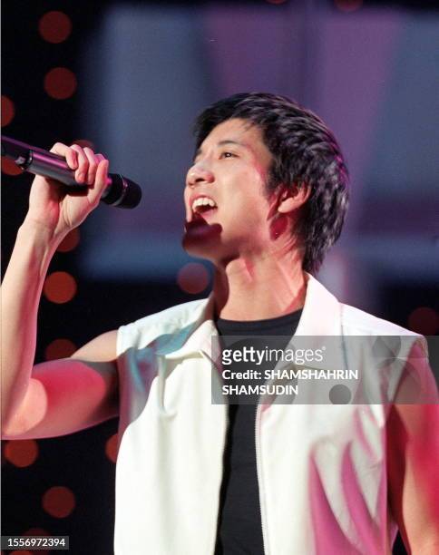Taiwanese singer Lee Hom sings his hit number `Julia' during a live telecast of a local television programme in Genting Highlands 07 August 1999. The...
