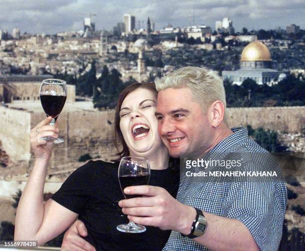 Bobbie Singer , Austria's entry in the Eurovision song contest, shares a toast with composer-lyricist Dave Moskin in front of a poster of Jerusalem...