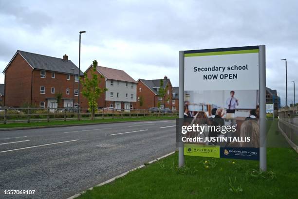 Sign advertising a newly opened Secondary School is pictured bear newly built residential properties at a Barratt and David Wilson construction site...