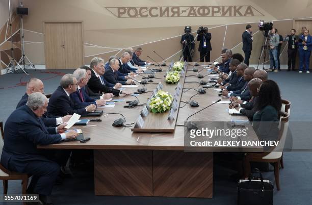 This pool image distributed by Sputnik agency shows Russian President Vladimir Putin meeting his Mozambique counterpart Filipe Jacinto Nyusi during...