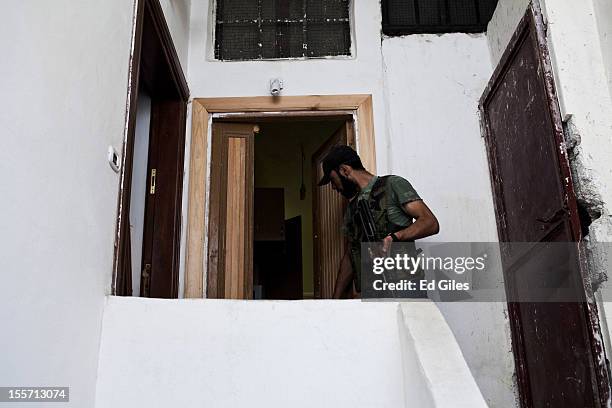 Fighter from the Shohada al Haq brigade of the Free Syrian Army moves into an apartment during a raid to clear a new apartment building in the...