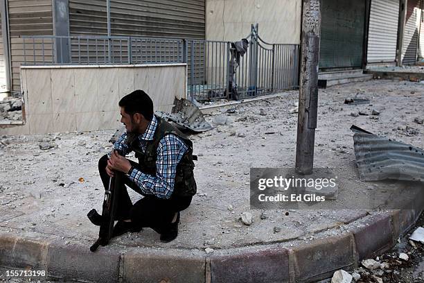 Fighters from the Shohada al Haq brigade of the Free Syrian Army sits on watch on a street corner near the Salahudeen district on November 1, 2012 in...