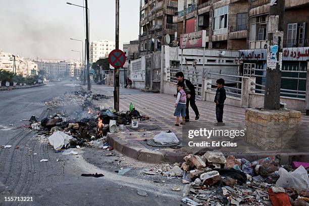 Syrian children play beside a burning pile of rubbish near the Salahudeen district on November 3, 2012 in Aleppo, Syria. The Shohada al Haq, or...