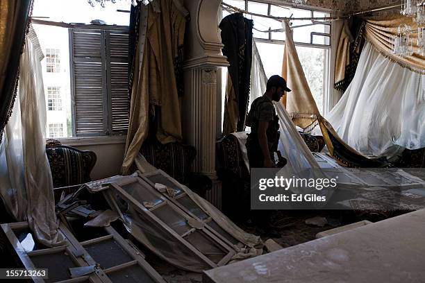 Fighter from the Shohada al Haq brigade of the Free Syrian Army stands in a damaged lounge room during a raid to clear a new apartment building in...