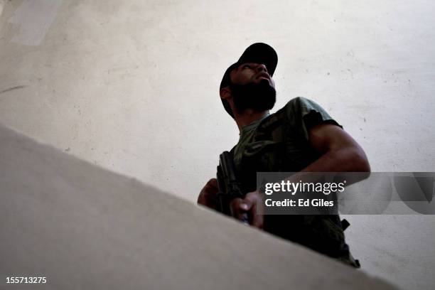 Fighter from the Shohada al Haq brigade of the Free Syrian Army moves up a set of stairs during a raid to clear a new apartment building in the...