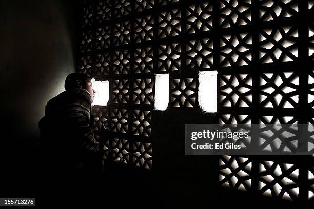 Fighter from the Shohada al Haq brigade of the Free Syrian Army peers through the gap in a wall during a raid to clear a new apartment building in...