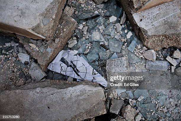 Sign warning people of nearby Syrian military snipers lies among debris on the ground near the Salahudeen district on November 6, 2012 in Aleppo,...