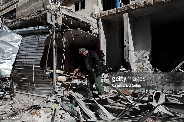 An elderly resident inspects his home, damaged by artillery fire during recent fighting near the Salahudeen district on November 4, 2012 in Aleppo,...