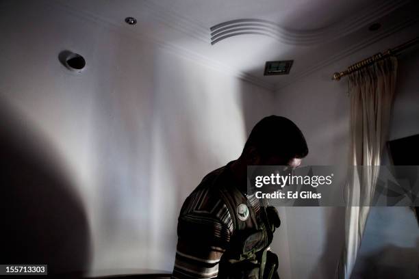 Fighter from the Shohada al Haq brigade of the Free Syrian Army moves through an abandoned room during a raid to clear a new apartment building in...