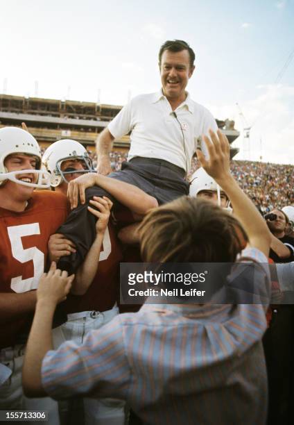 Texas head coach Darrell Royal victorious, being carried off the field by his players after winning game and clinching national title vs Arkansas at...