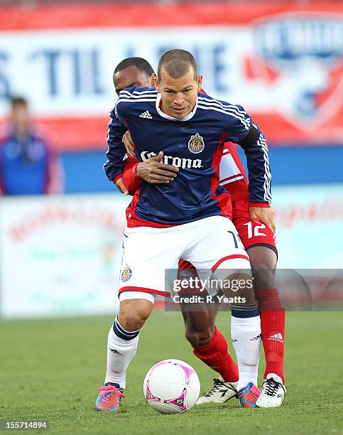 Alejandro Moreno of Chivas USA is challenged by Julian de Guzman of FC Dallas at FC Dallas Stadium on October 28, 2012 in Frisco, Texas.