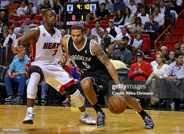 Deron Williams of the Brooklyn Nets drives against Dwyane Wade of the Miami Heat during a game at AmericanAirlines Arena on November 7, 2012 in...