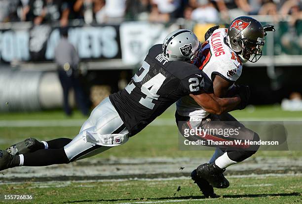 Mike Williams of the Tampa Bay Bucanneers gets dragged down from behind by Michael Huff of the Oakland Raiders during an NFL football game at O.co...