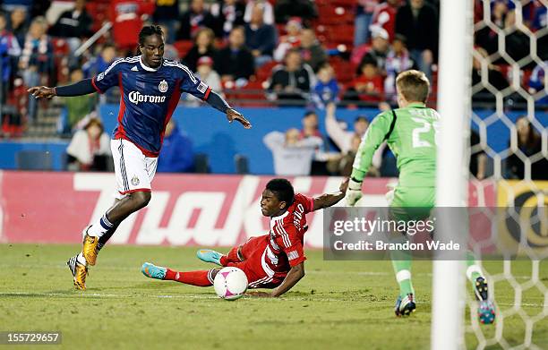 Fabian Castillo of FC Dallas is pushed off the ball as Shalrie Joseph of Chivas USA and goal keeper Tim Melia defend during the second half of a...