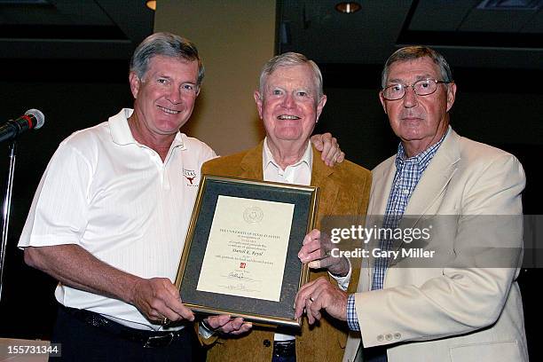 University of Texas football coach Mack Brown and Athletic Director DeLoss Dodds present former coach Darrell K Royal with a certificate recognizing...