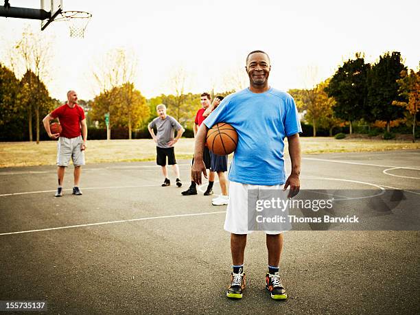 basketball player standing on outdoor court - mann 50 style stock-fotos und bilder