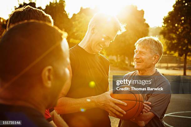 laughing group of basketball players on court - herren basketball stock-fotos und bilder