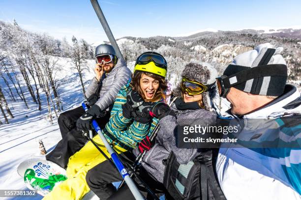 group of happy friends driving on a ski lift in winter day. - happy skier stockfoto's en -beelden