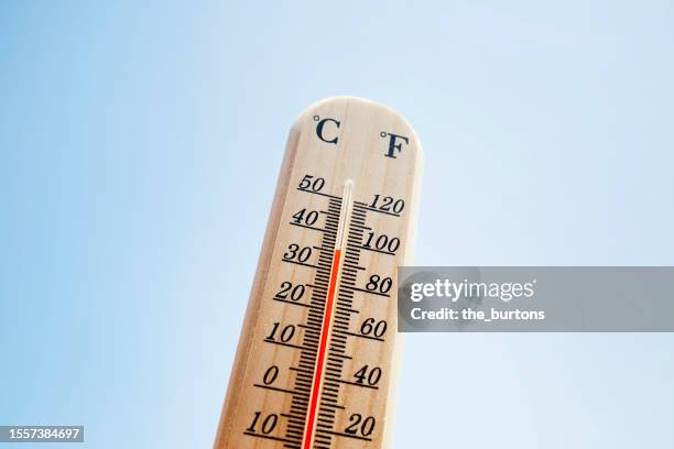 thermometer against blue sky - termometro foto e immagini stock