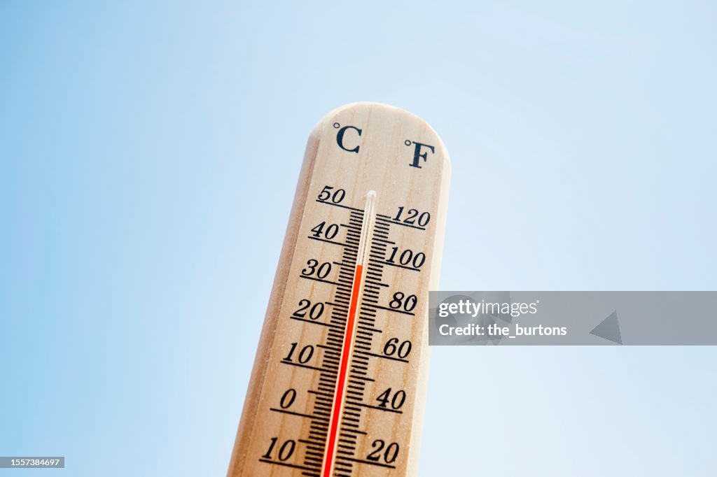 Thermometer against blue sky