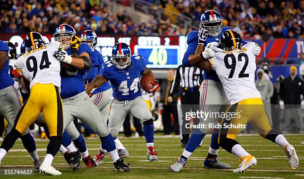 Running back Ahmad Bradshaw of the New York Giants finds a hole created by teammates Chris Snee and Will Beatty who block Ziggy Hood and James...