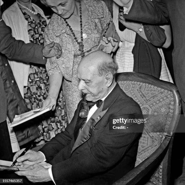 Photo taken 14 August 1960 in Prades of Spanish violoncellist and director Pablo Casals signing an autograph during the Prades Festival. Casals...