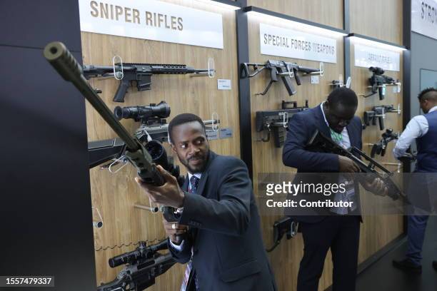 Participants look at weapons at the arms exhibition during the Second Summit Economic And Humanitarian Forum Russia Africa on July 27, 2023 in Saint...