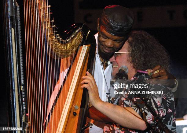 South African Pops Mohamed and Swiss Andreas Vollenweider embrace during a performance at the North Sea Jazz Festival Cape Town 29 March 2003. The...