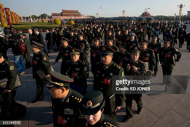 Military delegates walk on Tiananmen Square as they arrive at the opening session of the Chinese Communist Party's five-yearly Congress at the Great...