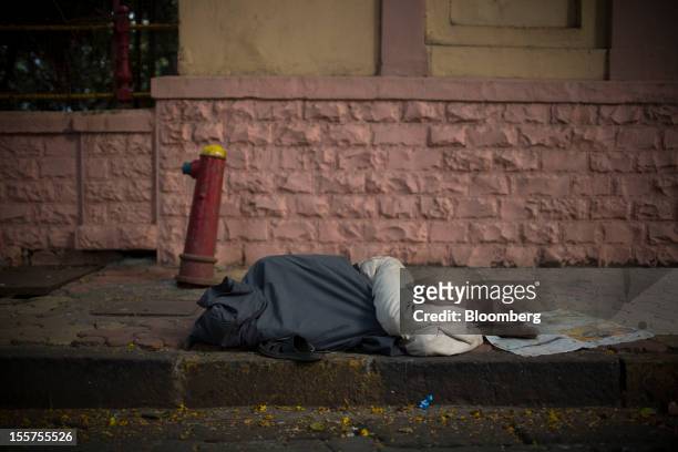 Man sleeps on the pavement in Mumbai, India, on Tuesday, Nov. 6, 2012. Reserve Bank of India Governor Duvvuri Subbarao lowered the RBI’s forecast for...