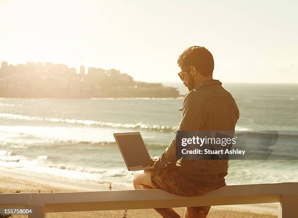 male in bondi with laptop - stuart gold stock pictures, royalty-free photos & images