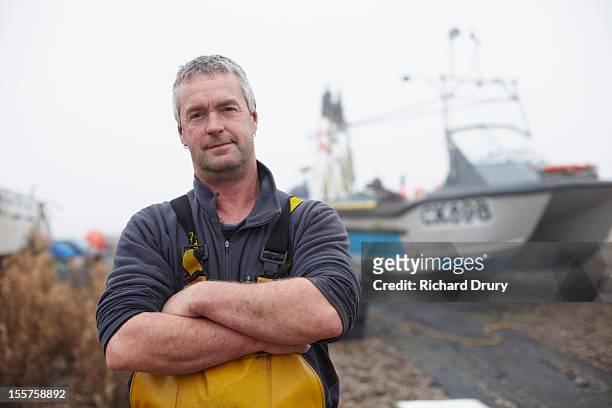 fisherman stood by his boat - portrait fisherman stock-fotos und bilder