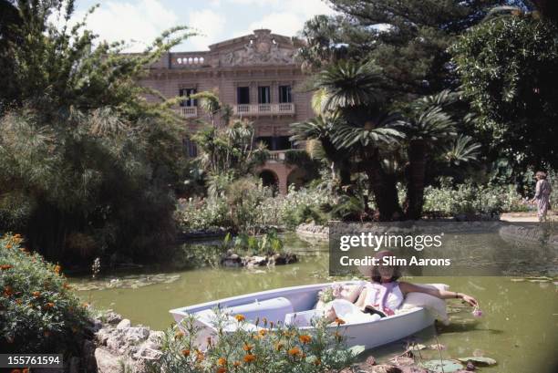 Donna Fabrizia Lanza di Mazzarino relaxing in a boat on a small lake in the grounds of the Villa Tasca d'Almerita in Sicily, Italy, in October 1984.