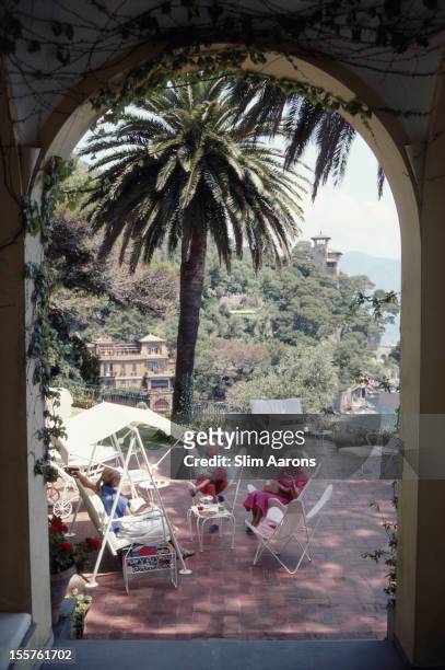 Beppe Croce and Umberta Croce relaxing in the shade of a palm tree on the terrace of their home in Portofino, Italy, in July 1985.