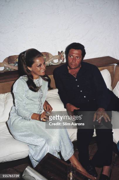 Italian actors Virna Lisi and Marcello Mastroianni sit together at an unspecified party in the Costa Smeralda region, Sardinia, Italy, August 1968.