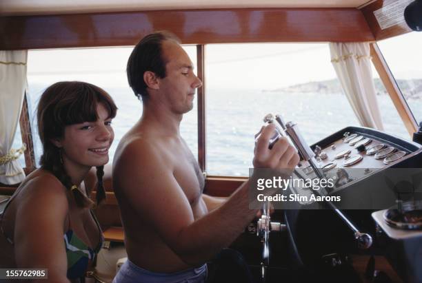 Yasmin Aga Khan and her half-brother, Prince Karim Aga Khan IV, who is at the controls of a yacht, on the waters off the coast of Porto Cervo on the...