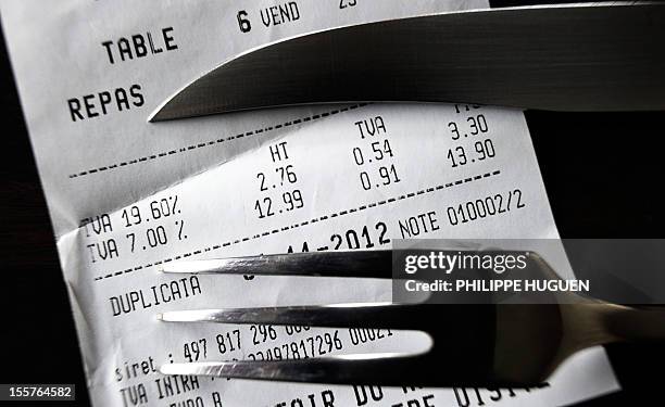 Picture taken on November 8, 2012 in a restaurant in Lille shows a fork and knife set up on a bill with the 19,60 percent value added tax , and the 7...