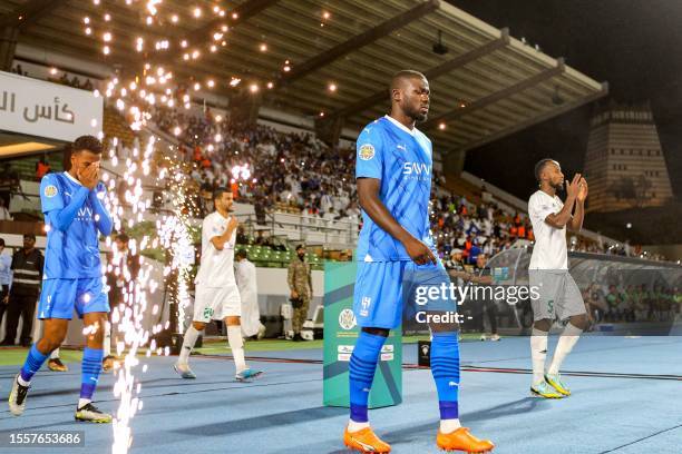 Hilal's Senegalese defender Kalidou Koulibaly walks onto the pitch with his teammates before the start of the 2023 Arab Club Champions Cup group B...