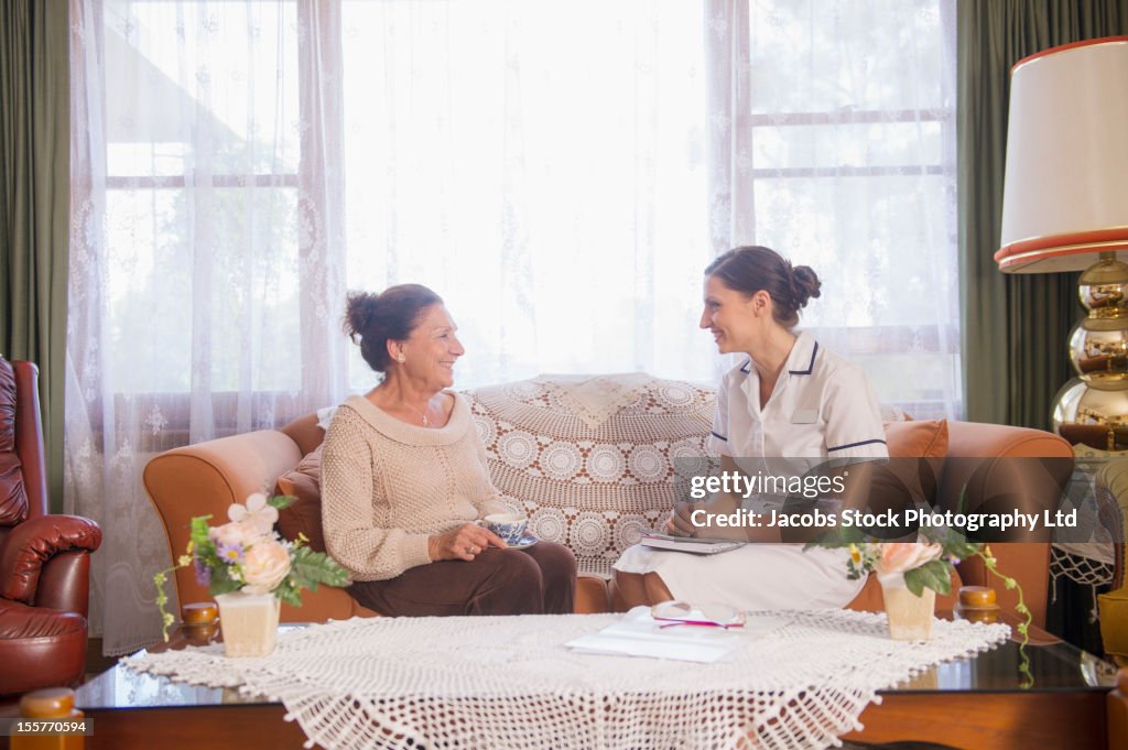 Hispanic nurse talking to senior woman