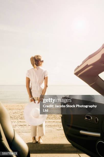 hispanic woman standing on beach - australia summer reflection stock-fotos und bilder