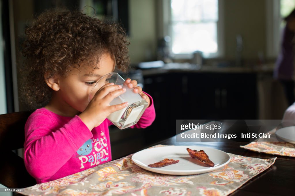 Mixed race girl drinking milk