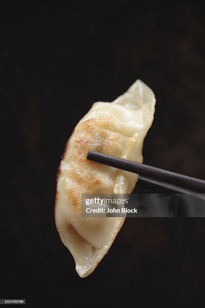 Chopsticks holding Asian dumpling