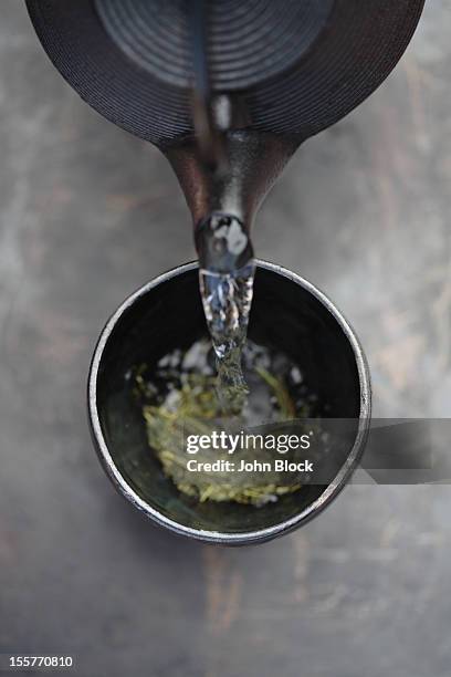 water being poured on tea leaves - cup of tea from above stock pictures, royalty-free photos & images