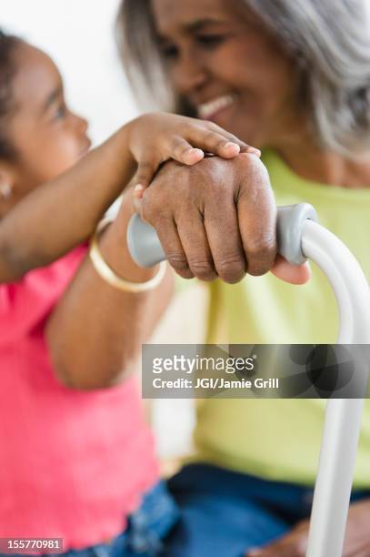 african american girl holding hands with grandmother - nonni bastone foto e immagini stock